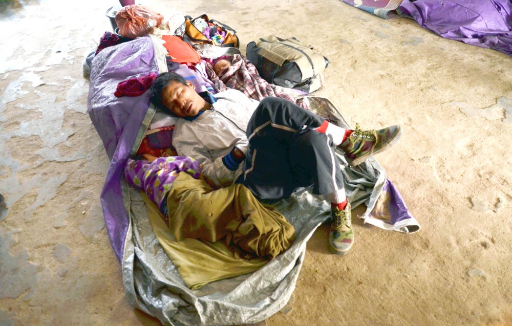 More than 2000 people were displaced by the violence in Karbi Anglong. Seen here is a displaced person with a child and a baby at a relief camp in Santipur, Bokajan. Displaced families have expressed the desire to go back to their villages and are being facilitated by the Assam police and the CRPF. Requests have been made to the Assam government to provide books, uniforms, bags and hostel facilities to students whose belongings were burnt in December. (Morung Photo/Caisii Mao)